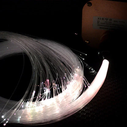 A coiled bundle of translucent white fiber optic light strands glowing softly in the golden music control twinkle LED RGBW kit