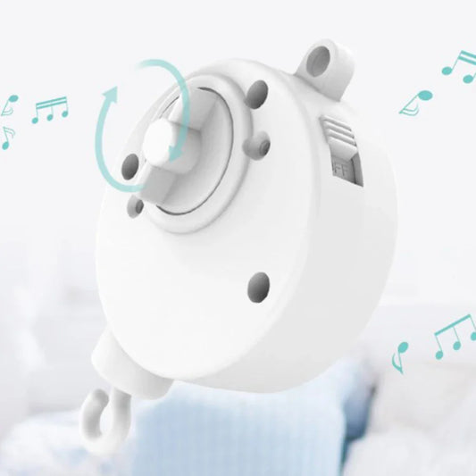 White plastic infant bell rotary lullaby machine with central knob and side vents for baby mobile crib bell windup movement