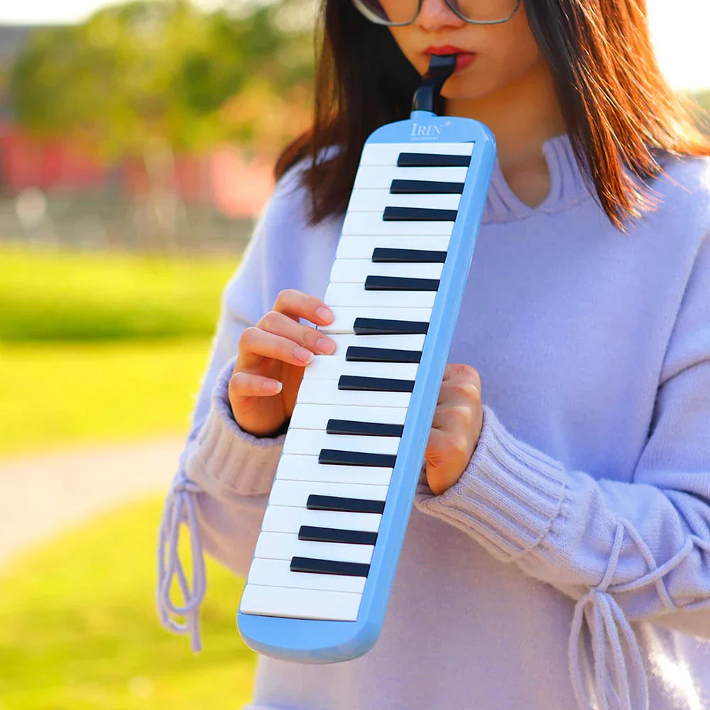 Light blue plastic keys melodica with black and white piano keyboard style musical instrument harmonica and carrying bag mouthpiece
