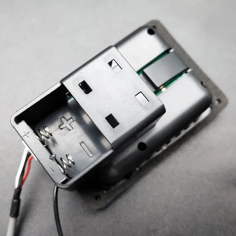 Black plastic usb battery holder with spring contacts and green circuit board inside joyo je-307 5-band soft piezo black