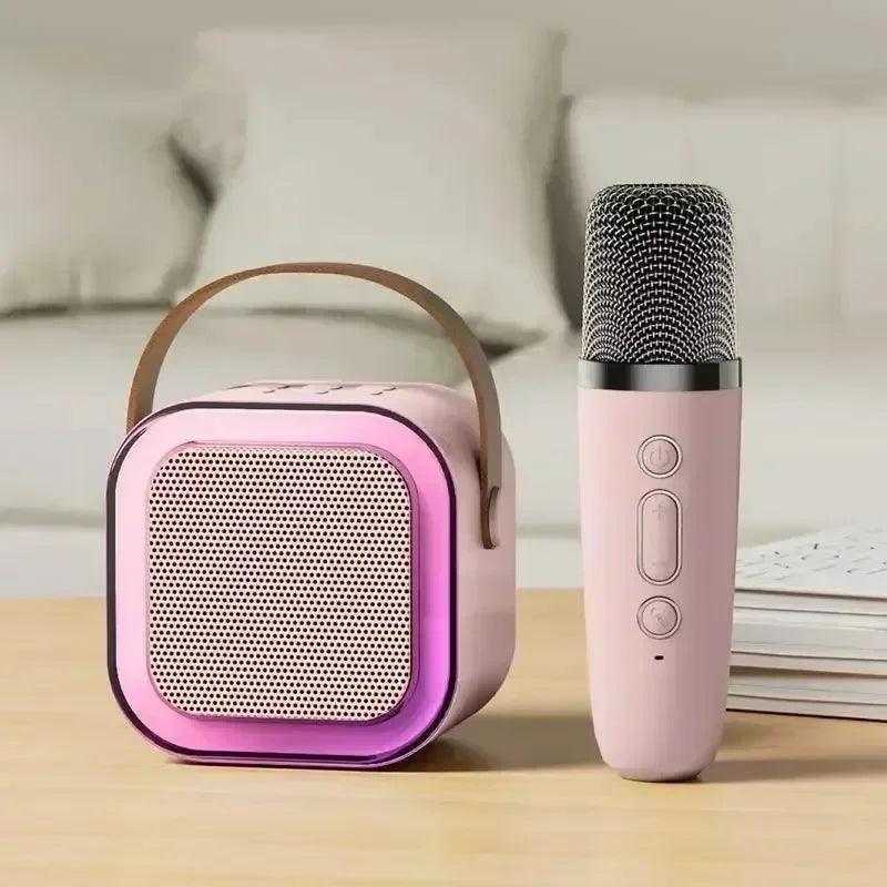 Pink k12 bluetooth portable speaker with brown leather handle and purple glowing edge paired with pink karaoke microphone