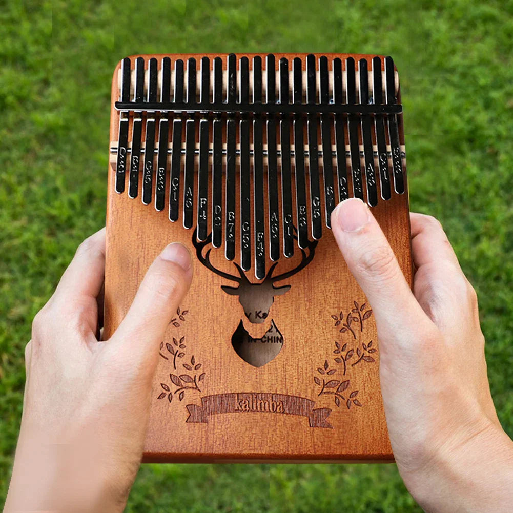 A professional thumb piano wooden kalimba with 21 black metal tines engraved deer head and brand name includes instruction carrying bag