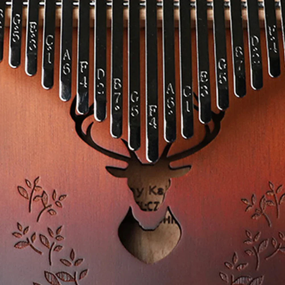A reddish-brown full wood professional thumb piano with black metal tines, deer head carving, and piano include instruction bag