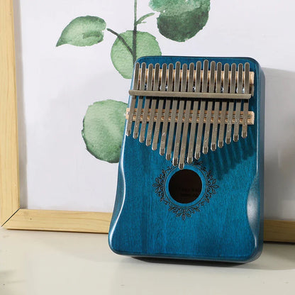 Blue wooden kalimba music instrument with silver metal tines and decorative circular sound hole portable finger piano