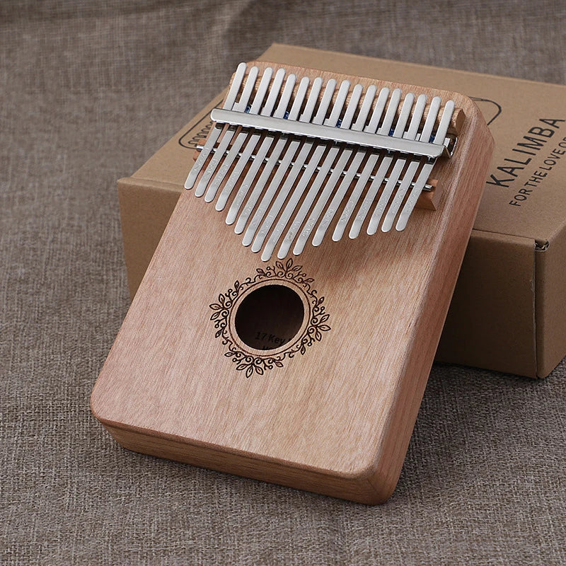 A light wood kalimba music instrument with silver metal tines and ornate sound hole perfect for kids portable mbira