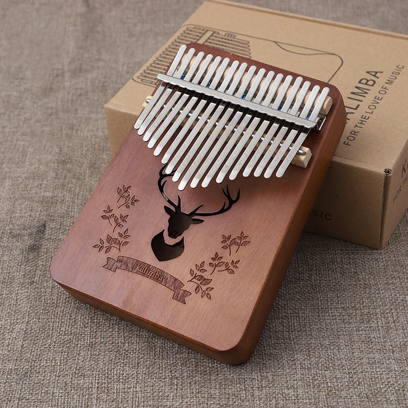A mahogany wood thumb piano kalimba music instrument with silver tines and deer engraving for kids portable use