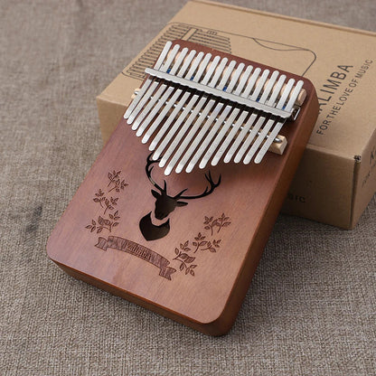 A mahogany wood thumb piano kalimba music instrument with silver tines and deer engraving for kids portable use