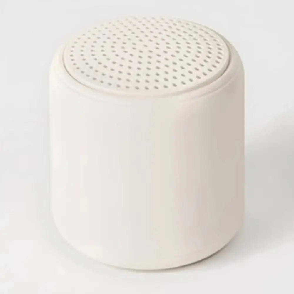 Cream-colored cylindrical karaoke mini bluetooth speaker with perforated top for rechargeable music wireless use