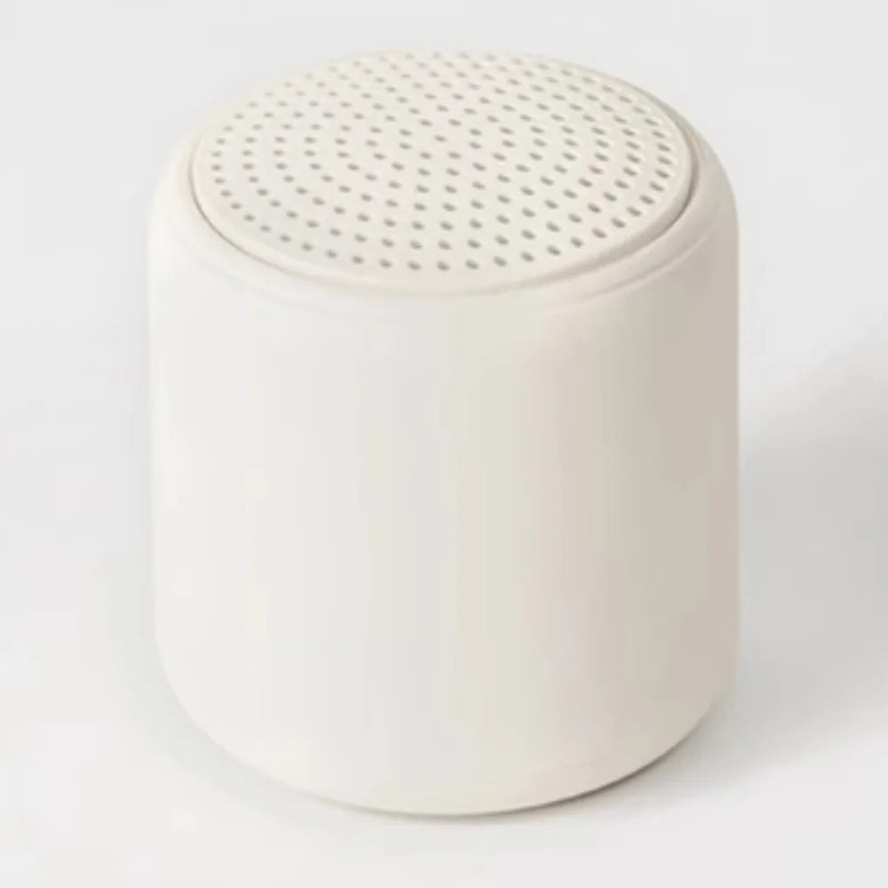 Cream-colored cylindrical karaoke mini bluetooth speaker with perforated top for rechargeable music wireless use