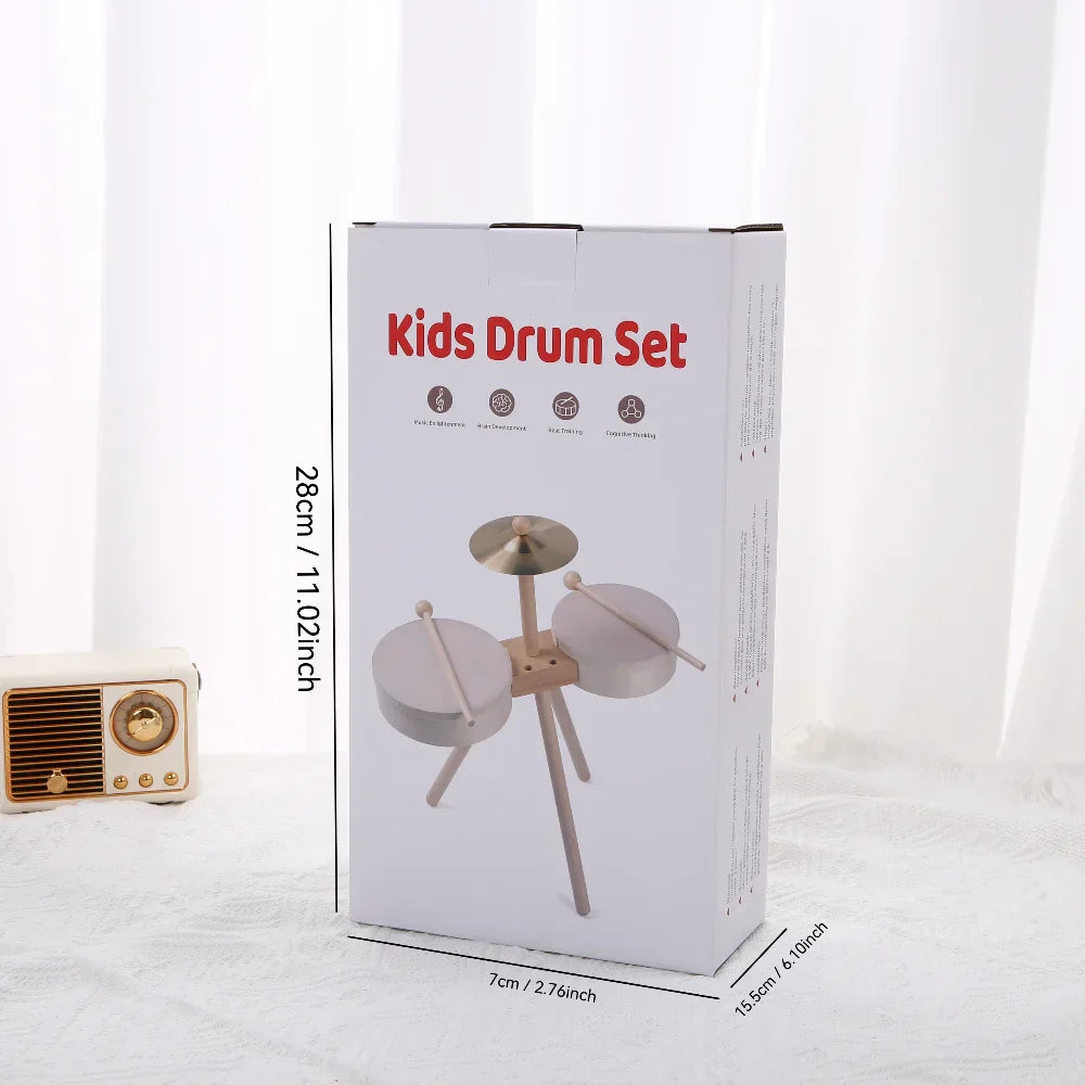 White cardboard box for kids drum set showing light wooden sticks and metallic cymbal, an educational percussion toy