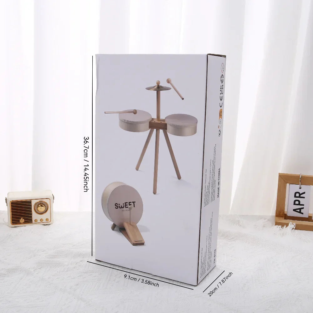 White cardboard box with wooden kids drum set featuring metallic cymbals and sticks branded sweet educational percussion toy