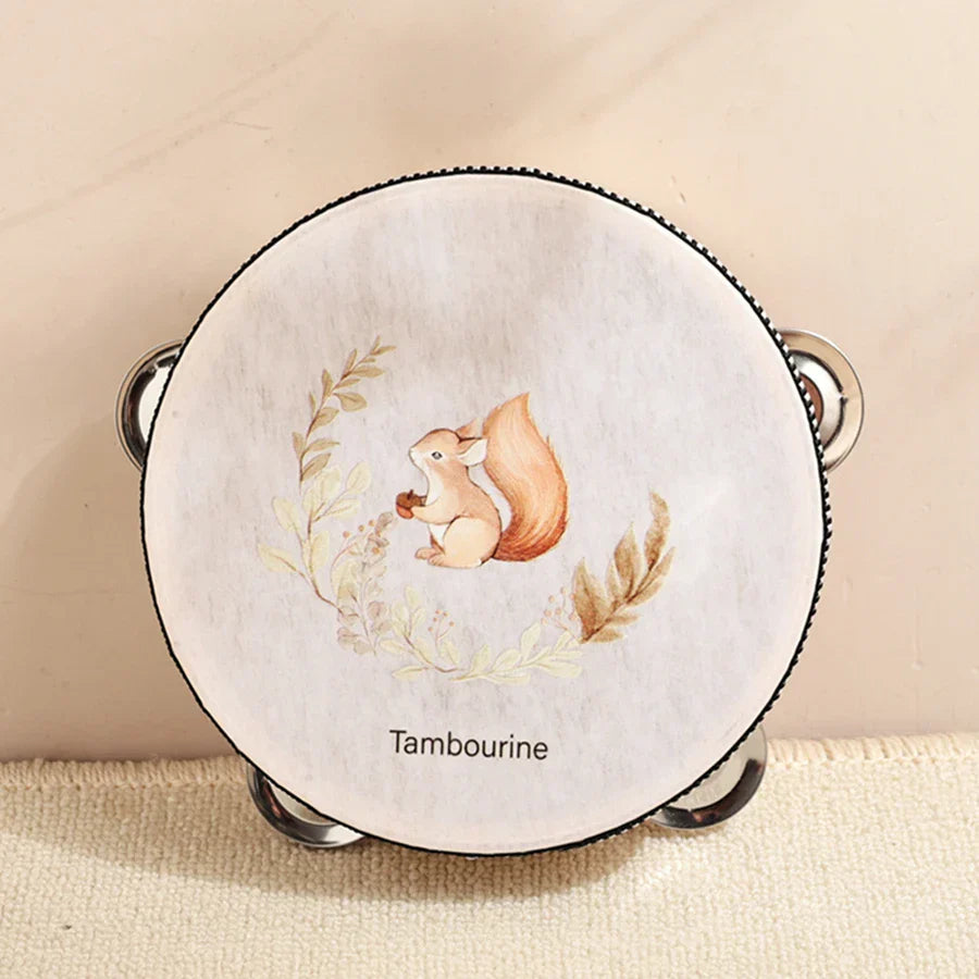 A round white kids wooden montessori tambourine with a squirrel percussion instruments illustration and leaves