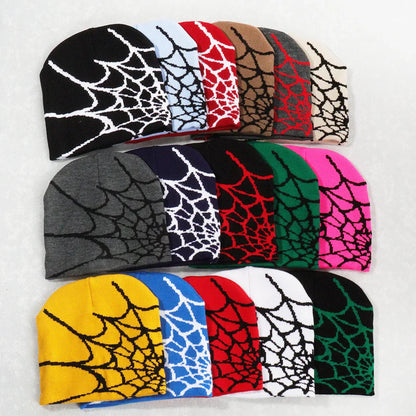 A collection of colorful knitted beanie hats featuring a bold black spiderweb pattern pile cap y2k goth style