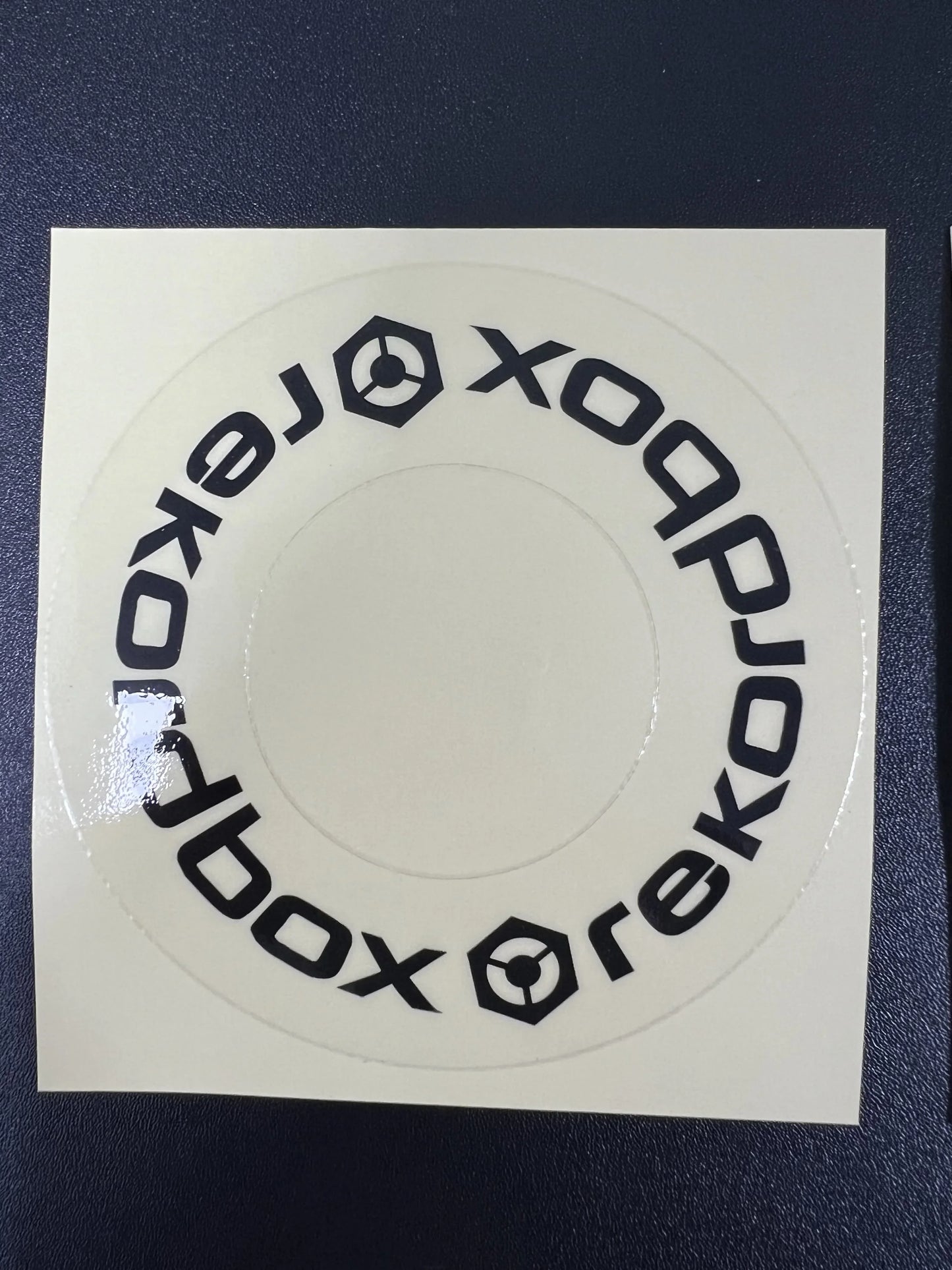 Black circular xobox sticker with hexagonal logo on transparent adhesive backing for large turntable protective film cdj
