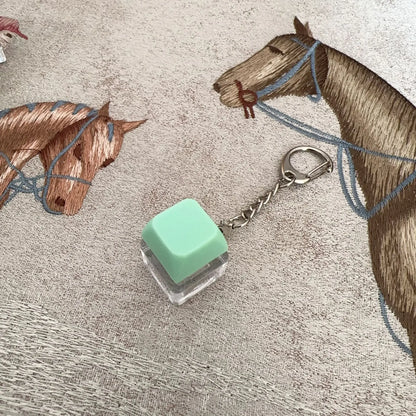 Mint green translucent keyboard key chain attached to silver ring for chain toy stress relief diy button use