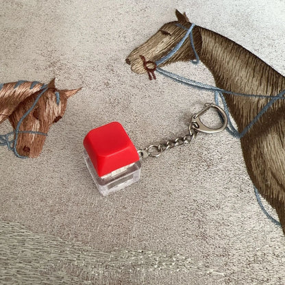 Red and clear plastic keyboard key chain with square translucent base and red top cap for chain toy stress relief diy button