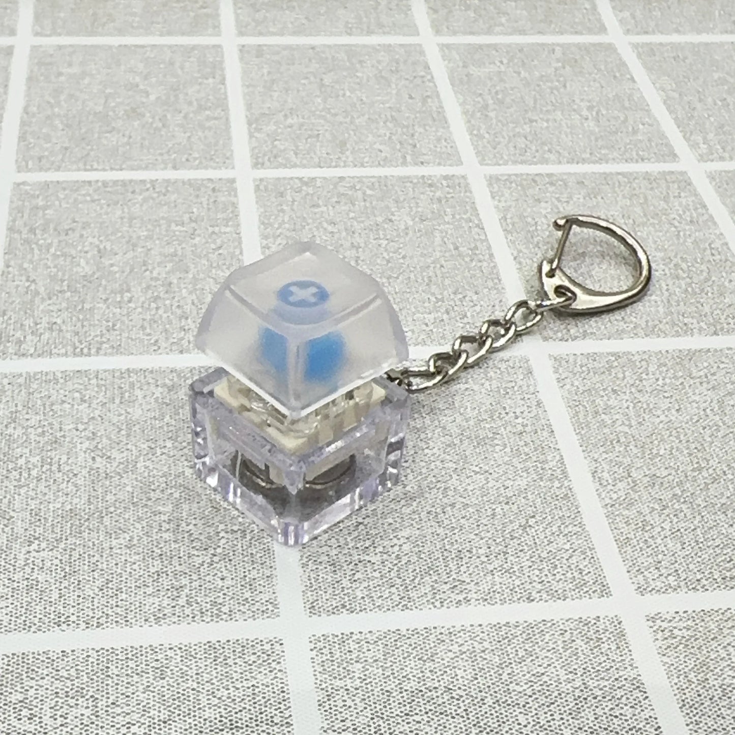 Clear plastic keyboard key chain featuring a blue tactile bump mechanical switch for chain toy stress relief diy button use
