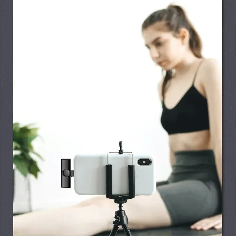 Black smartphone tripod holding white phone featuring lenovo k11 professional wireless lavalier microphone recording interview use