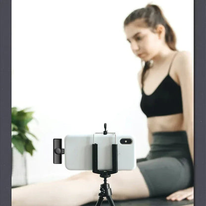 Black smartphone tripod holding white phone featuring lenovo k11 professional wireless lavalier microphone recording interview use