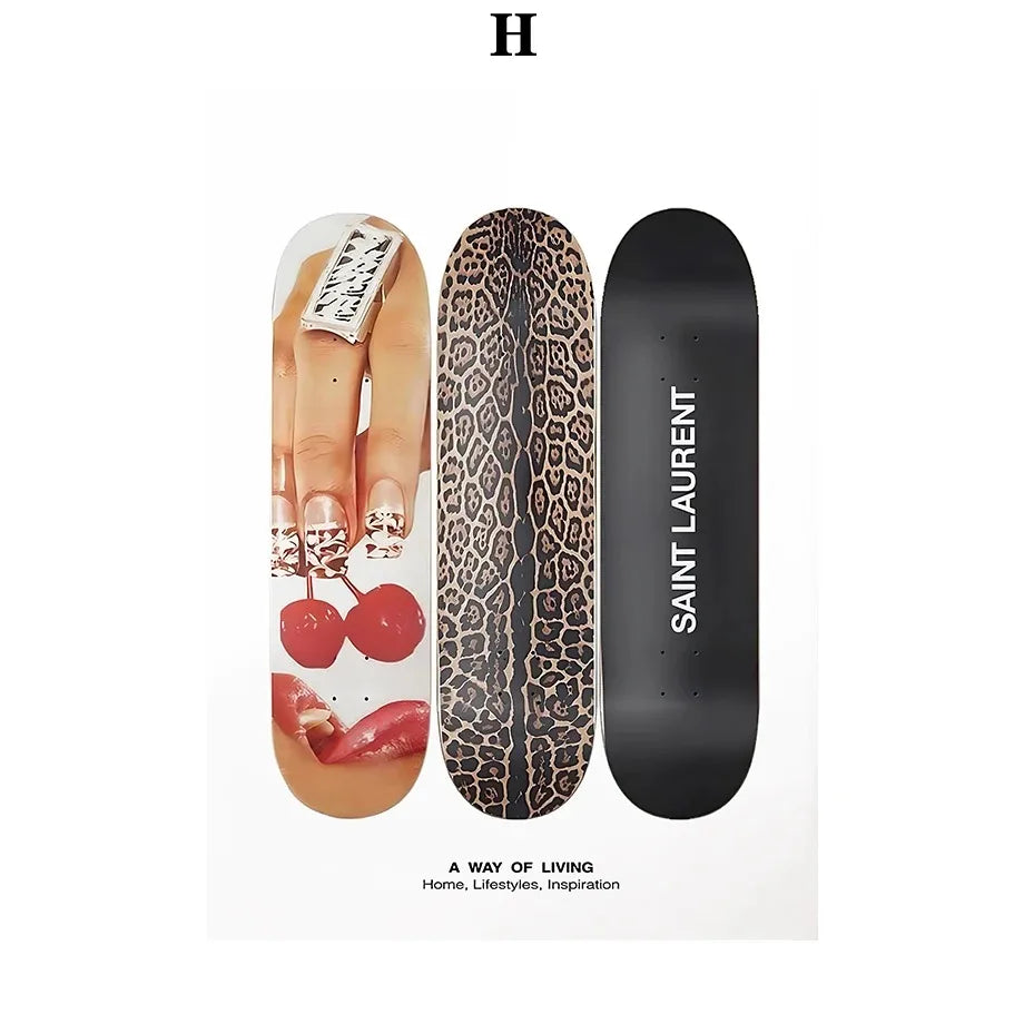 Three skateboard decks featuring a glossy photo of hands with rings and cherries, bold leopard print, and black saint laurent design