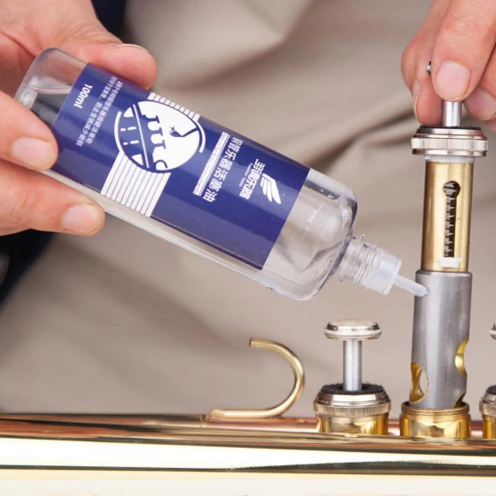 A clear plastic bottle with blue label containing 10ml trumpet cleaning solution for lubricating oil care saxophone valves oil