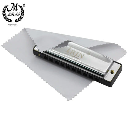Silver-toned m mbat blues harmonica with abs box, black plastic body, and gold tuning pin on white microfiber cloth
