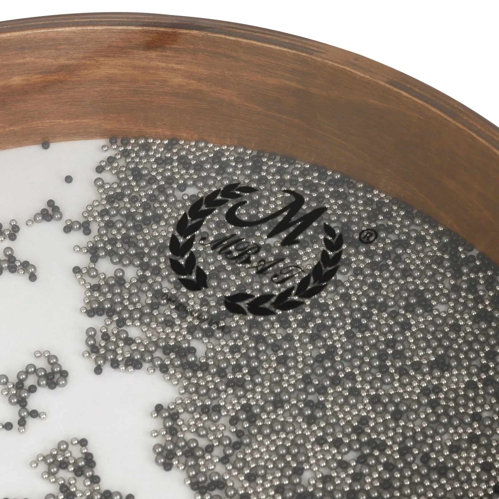 A wooden framed tray with small metallic silver steel balls for inch tambourine waves sound ocean drums