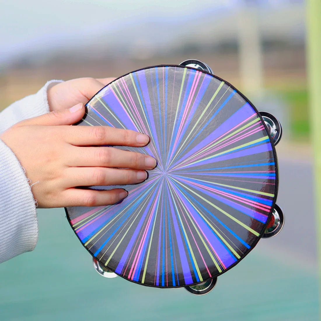 A vibrant 8 inch tambourine handbell hand with rainbow pattern wooden frame and shiny chrome jingles for music play