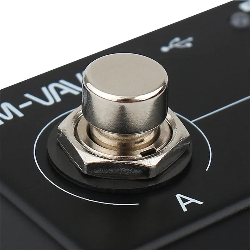 Shiny metallic push button with hexagonal base mounted on black panel for programmable wireless midi guitar pedal