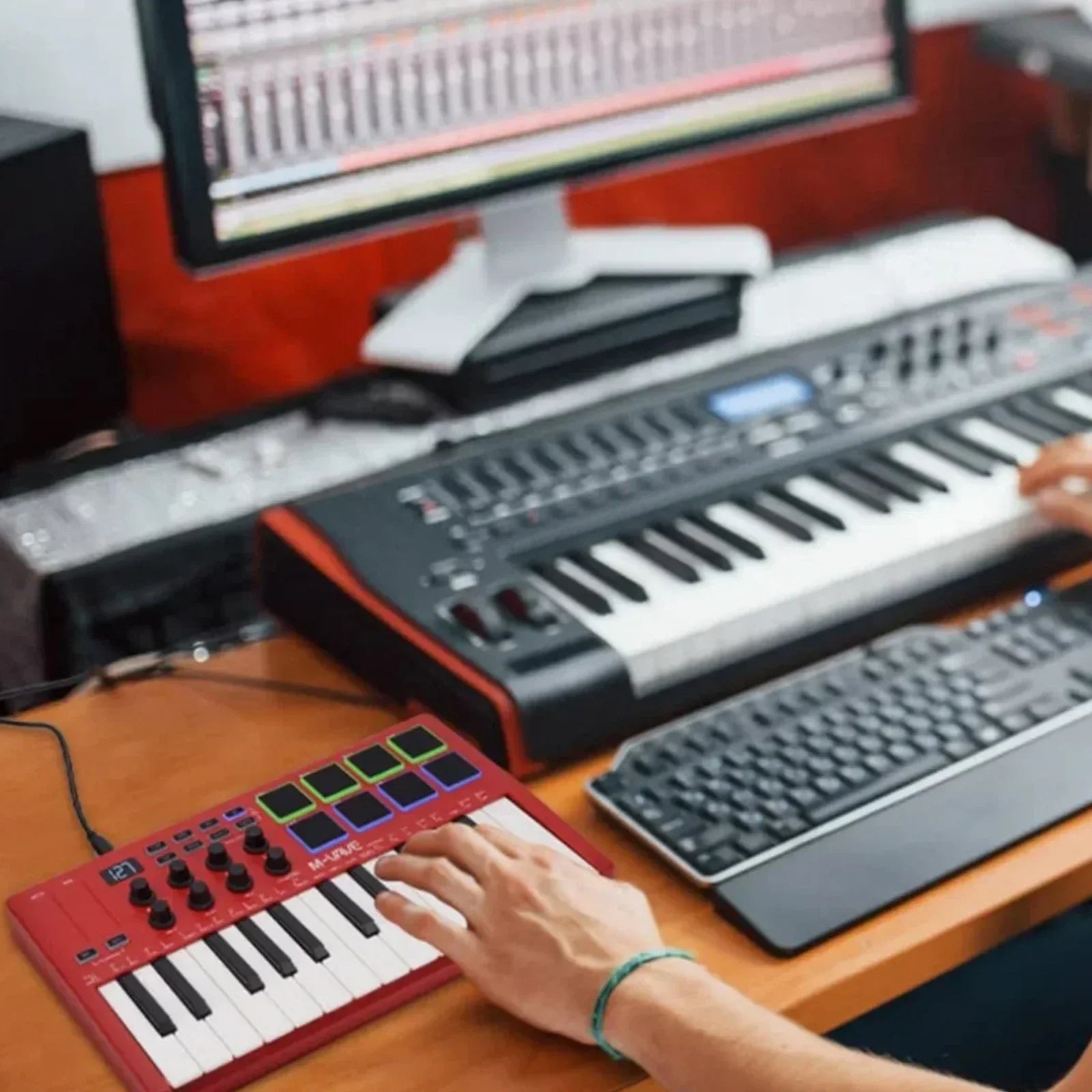 Red m-audio keystation mini keyboard with rgb drum pads and assignable knobs for portable midi pad controller use with music production software