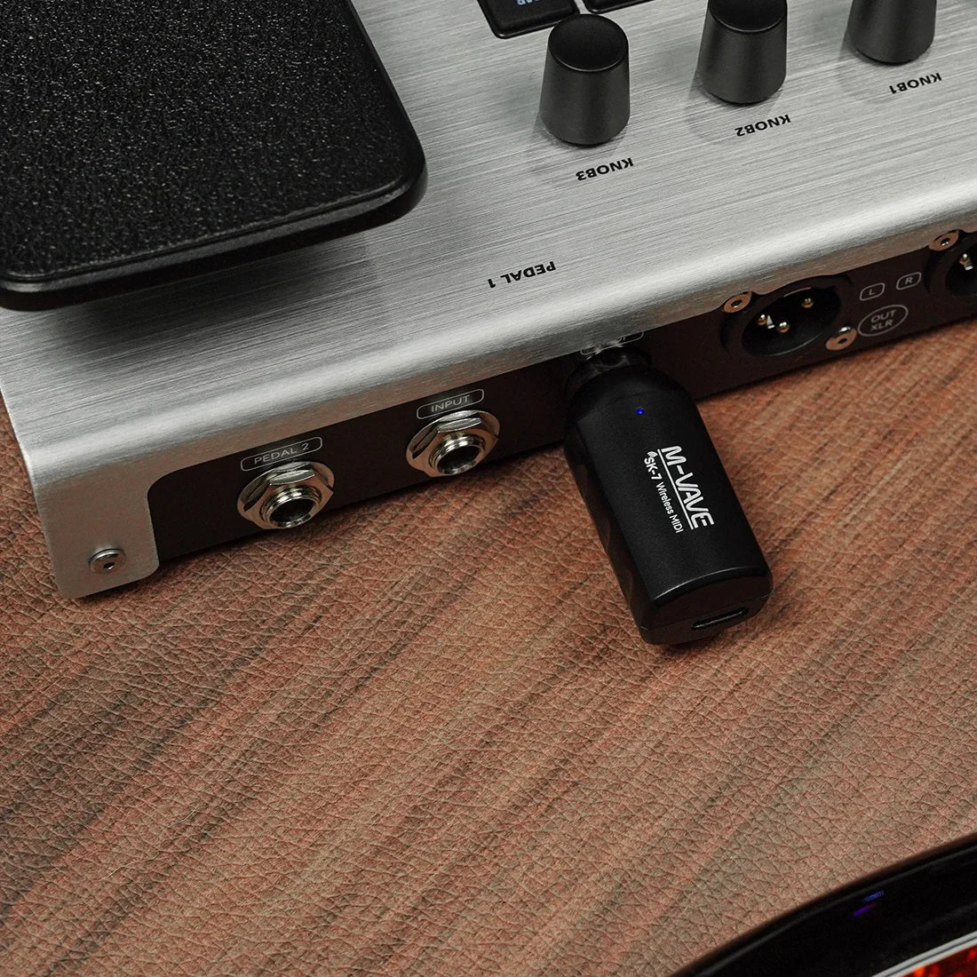 Black m-audio usb audio interface adapter with blue led plugged into pedalboard as wireless midi sk7 midi adapter mini