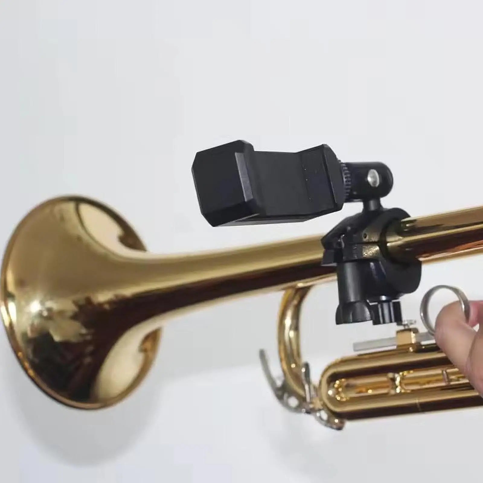 Black adjustable microphone clip mounted on brass trumpet as a sturdy lyre phone holder for marching band music