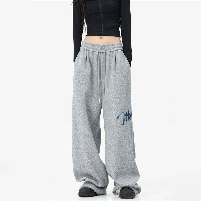 Men’s gray heathered printed wide leg sweatpants with drawstring waistband and navy blue lettering for y2k streetwear baggy hip hop fashion