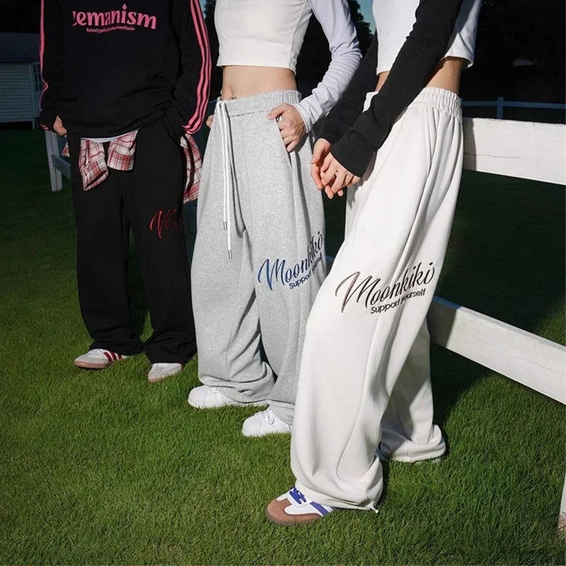 Men’s gray and white printed wide leg sweatpants with moonkiki support yourself text for y2k streetwear baggy hip hop fashion