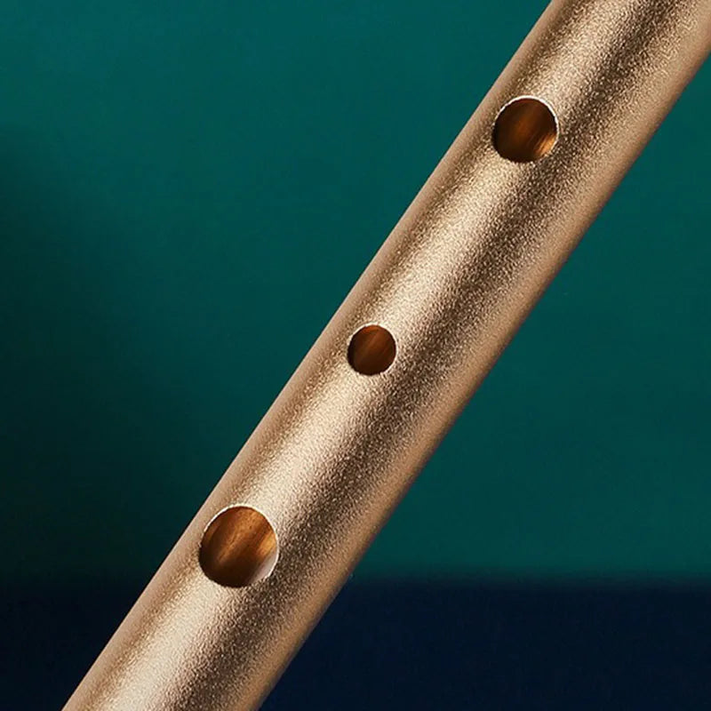 A matte gold metal irish whistle with three finger holes for student playing recorder and professional performance irish use