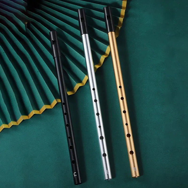 Three metal irish whistles in black silver and gold with evenly spaced finger holes for student playing recorder use