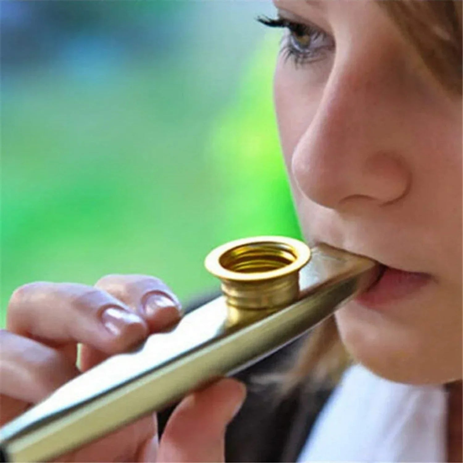 Gold-colored metal kazoo accompaniment with shiny metallic finish and circular mouthpiece for guitar ukulele beginner use