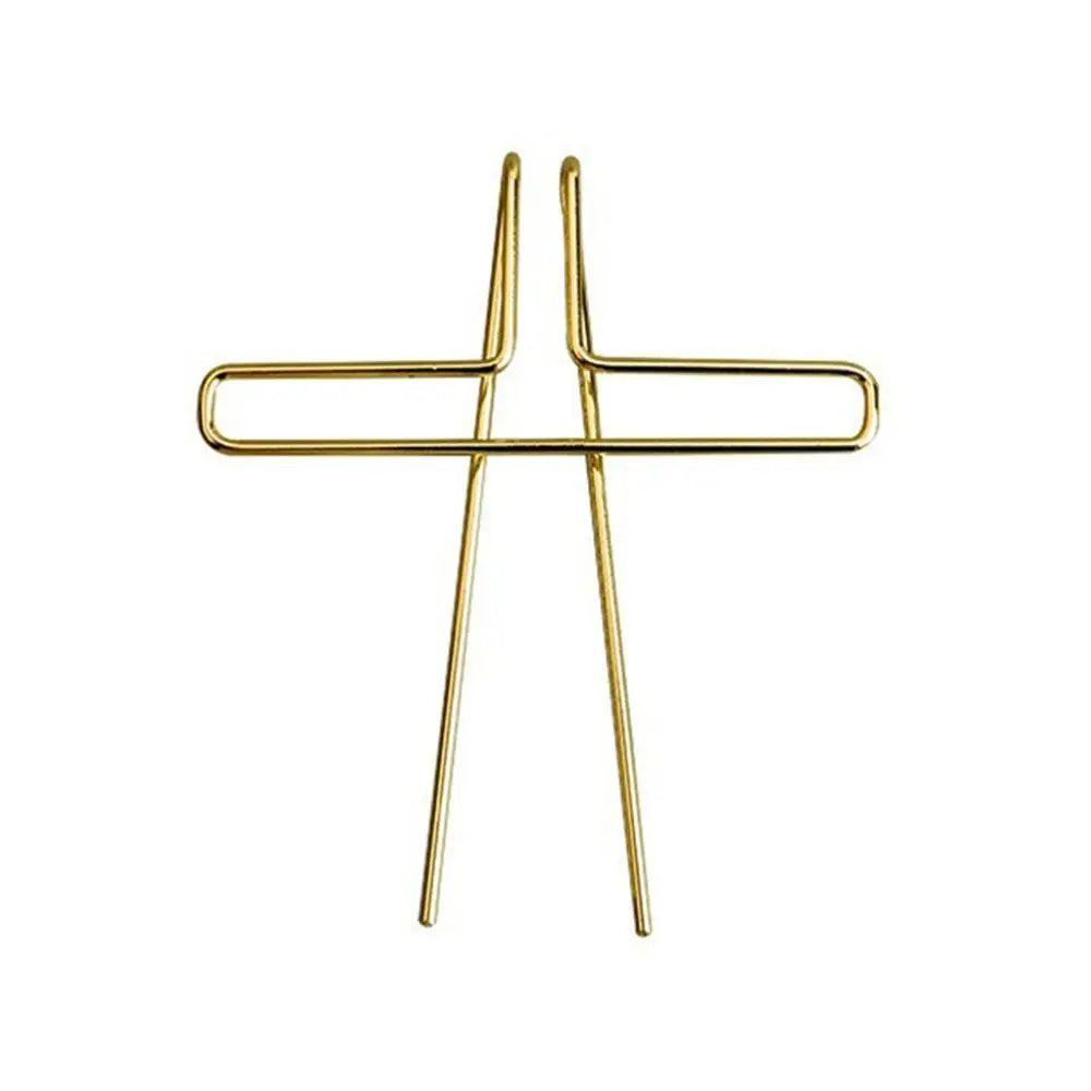 Gold-colored metal music book clip shaped as a cross for page holder pianos and cooking recipe magazines