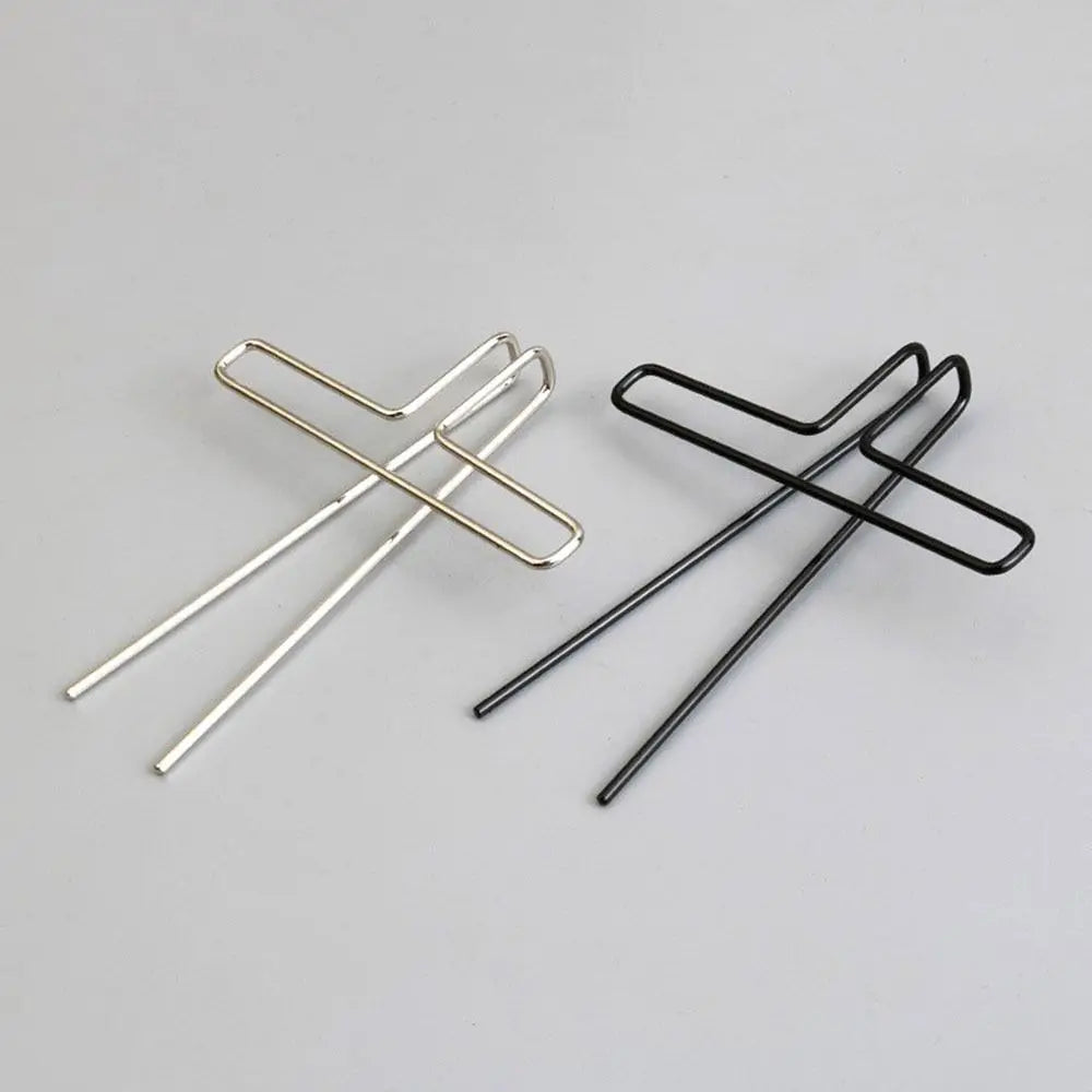 Two minimalist metal music book clips in polished silver and matte black with cross-shaped design for page holder pianos and cooking recipe magazines