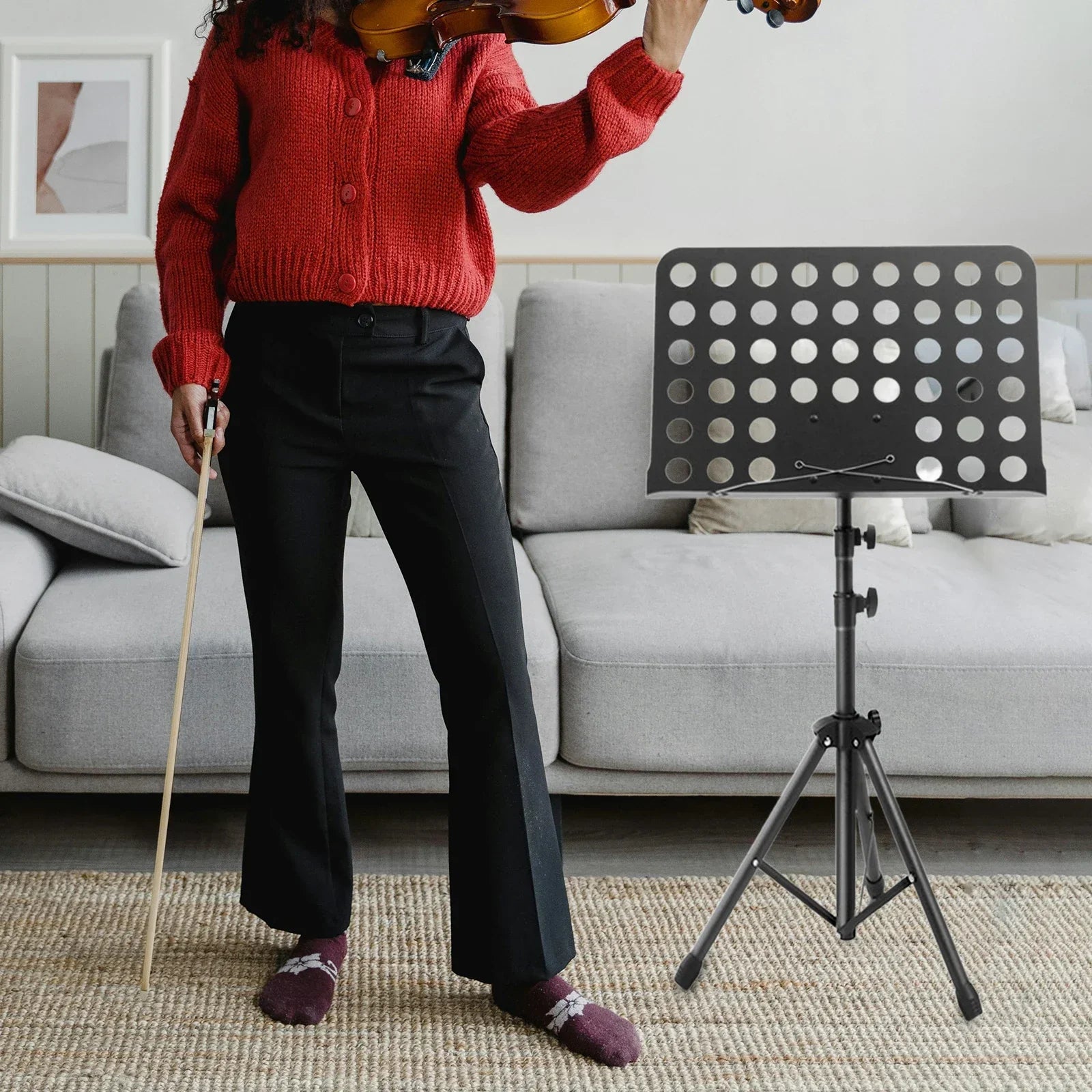 Black metal music stand with circular cutouts and adjustable tripod legs for guitar violin ukulele and piano desk stand use