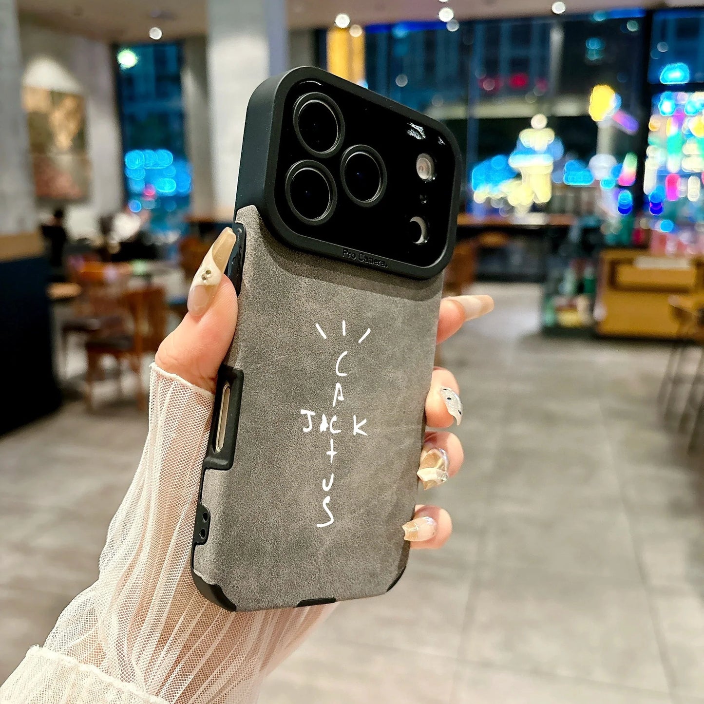 Back side of gray microfiber leather phone case with black camera bump and white cactus jack lettering for cover 16e luxury music jack cases