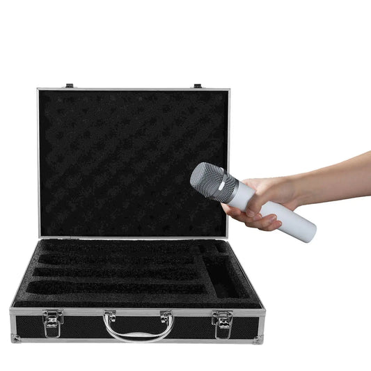 A white handheld microphone with silver mesh grille held above black foam-lined microphone carrying studio case for mics storage broadcast
