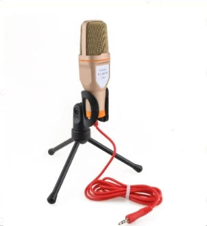 Gold-colored condenser microphone with mesh grille and red cable for professional sound podcast studio and laptop skype singing
