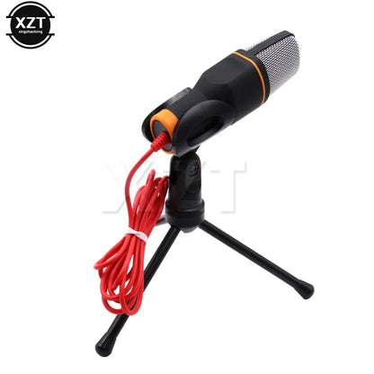 Black and orange usb microphone with silver mesh grille on tripod stand for professional sound podcast studio laptop skype singing