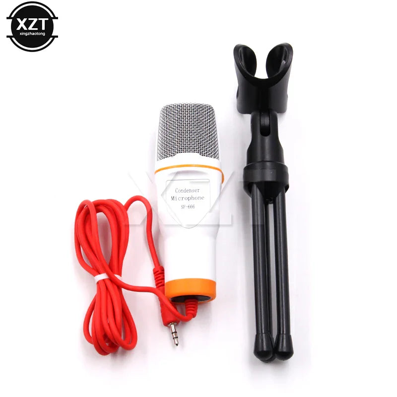 White and orange condenser microphone with silver mesh grille on black tripod stand and red cable for laptop skype singing and podcast studio