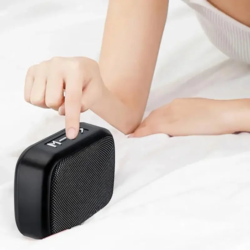Black rectangular portable wireless soundbar with textured grille and minimalist buttons for indoor and outdoor use