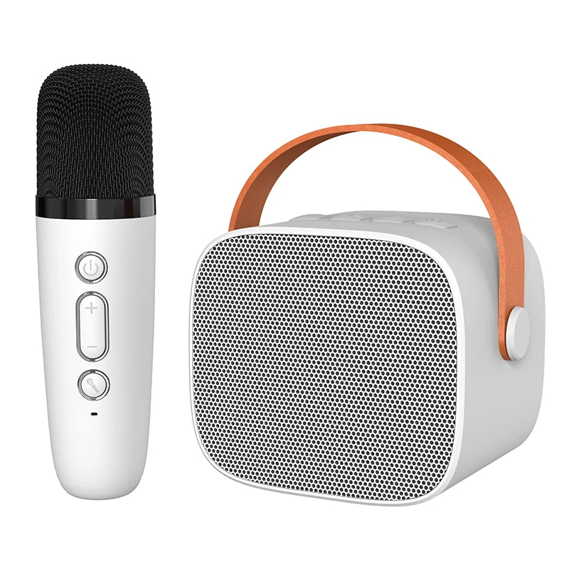 White wireless microphone with black mesh and silver buttons next to white kids portable speaker with orange strap for karaoke machine