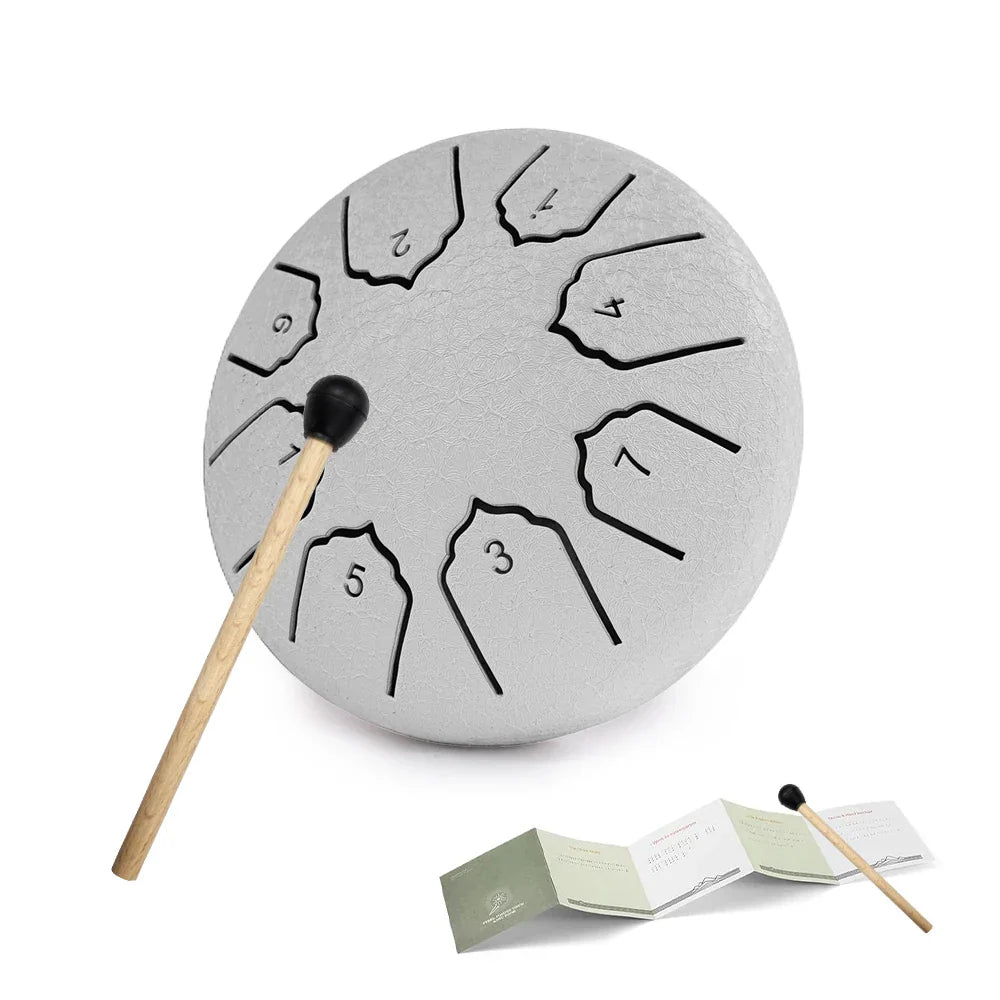Gray steel tongue drum with black number markings and wooden stick with rubber tip for notes rain drum use outdoors