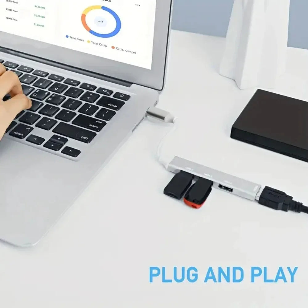 Silver mini usb type c hub with drag four expanders featuring multiple ports and two black and red flash drives attached