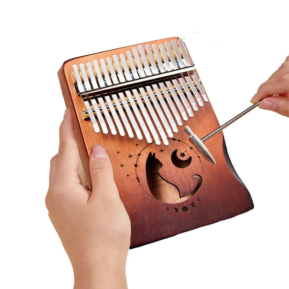 A mahogany wood beginner musical instrument cat kalimba thumb piano with silver tines and carved cat and moon design